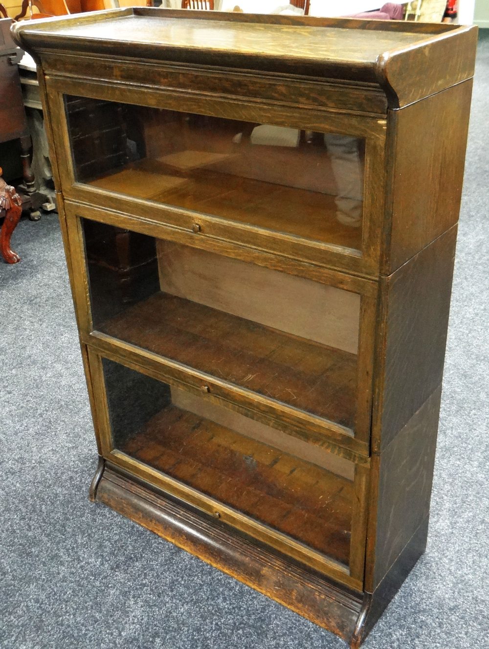 A THREE SECTION GLOBE WERNICKE-STYLE LIBRARY BOOKCASE in dark oak, 87cms wide