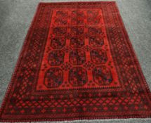 A RED AFRICAN CARPET WITH TRADITIONAL BOKHARA DESIGN, 288 x 194cms