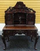 A JAPANESE MEIJI CARVED DESK with cabinet and recess top, having a base of two drawers, heavily