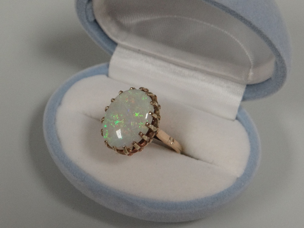 A 9CT GOLD OPAL RING, the opal measuring 14mms long in a sixteen claw setting, 4.54gms