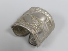 AN ALEXIS KIRK (1936-2010) WHITE METAL HINGED BANGLE WITH TEXTURED LEAF FINISH