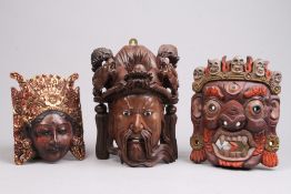 Drei Masken.Verschiedene Hölzer, teils sehr fein geschnitzt, teils farbig und vergoldet. H: bis 32
