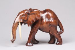 Holzfigur.Elefant geschnitzt, Stoßzähne aus Bein. H: 16 x 24 cm.