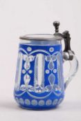 Glaskrug.Böhmen 1. H. 19. Jh. Farbloses Glas, weiß und blau überfangen, mit Schälschliff verziert.