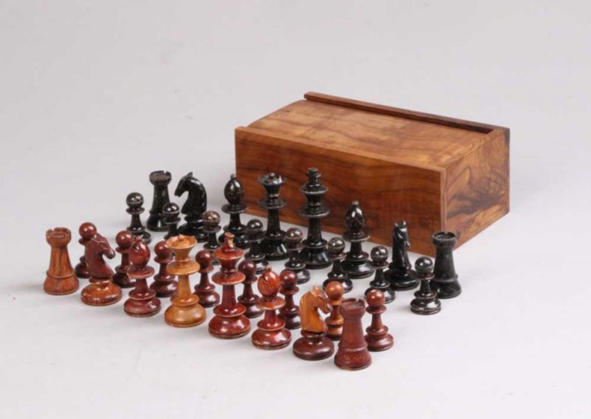 Schachfiguren.32 Spielfiguren in Schatulle aus Olivenholz. Holz, gedrechselt und geschnitzt. H: