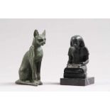 Zwei FigurenUm 1900. Keramik. Katze und Ägypter mit Schriftrolle, sitzend auf Marmorsockel.