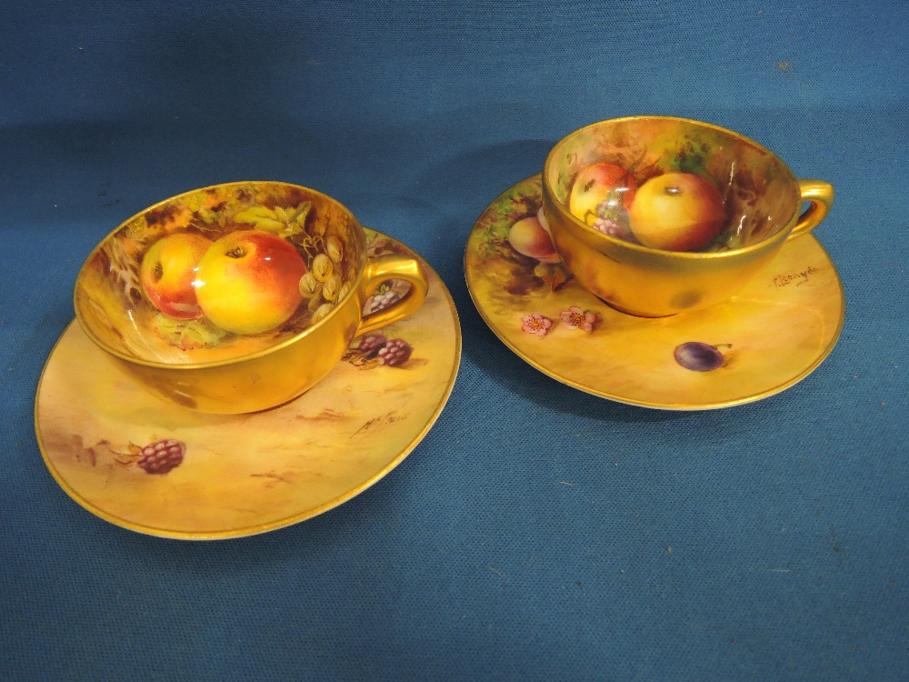 A pair of Royal Worcester cabinet cup and saucers having painted still life decoration by