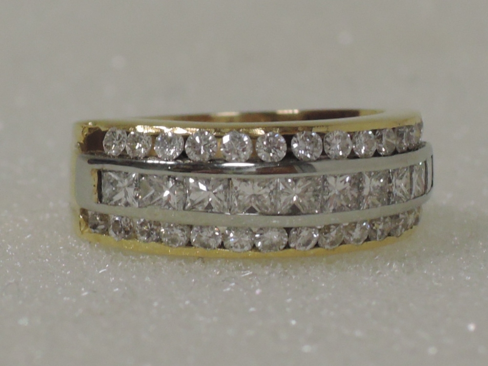 A ladies dress ring having a central row of 10 princess cut diamonds flanked by two rows of