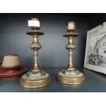 A pair of early 20th century brass candlesticks having a cloisonne band