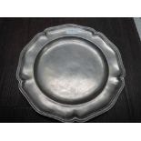 A 19th century pewter plate of scallop design bearing touch mark JCD