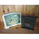 An Edwardian tin plate money box modeled as a fireplace and a 1960's childs clock, Goldilocks