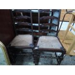 A pair of dark stained ladder back kitchen chairs