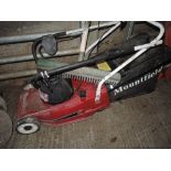 A Mountfield petrol lawn mower and hand rake