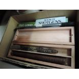 A box of shooting related volumes and a gun cleaning kit
