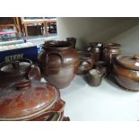 A shelf of various salt glazed pots and jars etc.