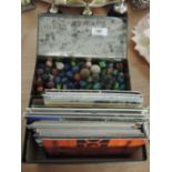A box of marbles and a box of vintage postcards