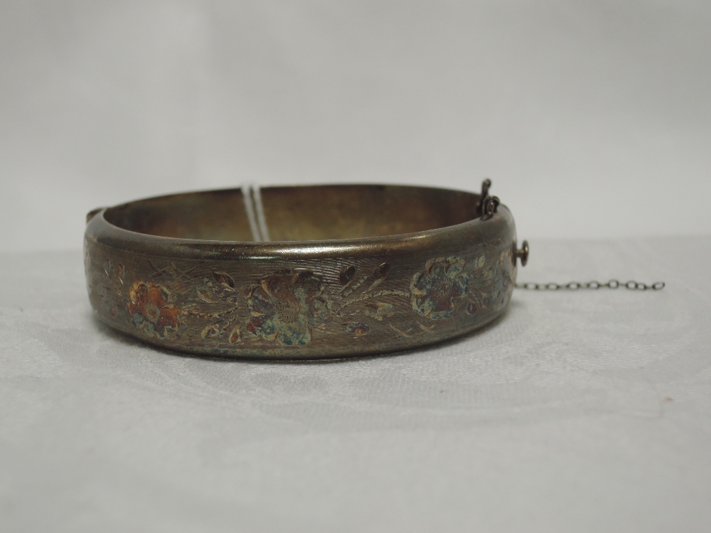 An HM silver hinged bangle having floral engraved decoration