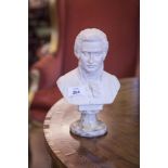 A WHITE PLASTER BUST OF MOZART, on a marble base.