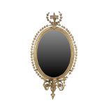 A 19TH CENTURY OVAL GILT GESSO WALL MIRROR, in the Neo-Classical taste, with three-light sconce, the