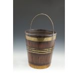 A 19TH CENTURY MAHOGANY COOPERED FUEL BUCKET of compact proportions with slender brass swing
