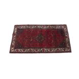 A PERSIAN WOOL CARPET, 20th century, of rectangular form, with broad centre field woven with