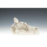 A CHINESE BLANC DE CHINE MODEL OF RECUMBANT GUANYIN, resting on a bed of lotus pods. 29cm wide