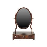 A GEORGE III MAHOGANY TOILET MIRROR, of oval form, raised on scrolling supports, the crossbanded