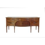 AN EARLY 19TH CENTURY SHERATON STYLE INLAID MAHOGANY SERPENTINE FRONT SIDEBOARD, the crossbanded top