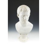 A PLASTER CAST BUST OF A ROMAN, after the antique, on circular socle base. 65cm high