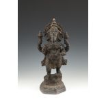 AN INDIAN BRONZE FIGURE OF GENESH, standing upright wearing traditional Buddhist costume holding