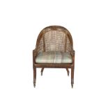 A 19TH CENTURY WALNUT FRAMED LOOP BACK BERGERE ARMCHAIR, the crest rail and seat fascia carved