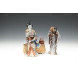 A JAPANESE PORCELAIN GROUP OF A BINJIN SEATED, holding a scroll and wearing a colourful kimono, with