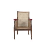 A REGENCY MAHOGANY FRAMED BERGERE ARMCHAIR with reeded rim, padded armrests, cane seat, back and