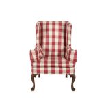 A GEORGIAN STYLE MAHOGANY FRAMED WING BACK ARMCHAIR, in checkered upholstery, raised on shell capped