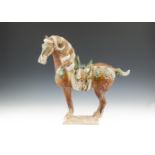 A CHINESE SAUCAI GLAZED POTTERY MODEL OF A HORSE, in the traditional Tang style, glazed in green,
