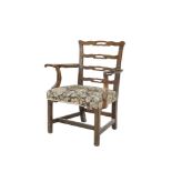A GEORGE III MAHOGANY FRAMED PIERCED LADDER BACK ELBOW CHAIR with outswept armrests, padded seat and