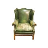 A GEORGIAN STYLE MAHOGANY FRAMED UPHOLSTERED GAINSBOROUGH WINGED ARMCHAIR covered in green hide