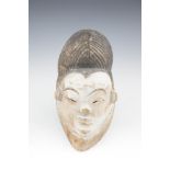 AN ASHIRA BPUNA STILT DANCER'S MASK, Gabon, eary 20th Century, carved in the form of a young female,