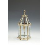 A SMALL BRASS SHAPED CIRCULAR LANTERN with five curved clear glass panels and raised on ball feet.