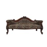 A LARGE VICTORIAN MAHOGANY FRAMED UPHOLSTERED BUTTON BACK COUCH, the arch crest with carved vine and