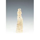 A JAPANESE CARVED IVORY OKIMONO, modelled as a figure standing atop a carp, signed. 16cm high