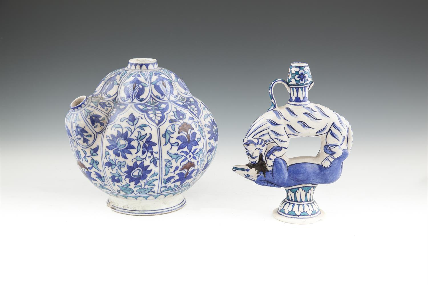 AN IZNIK STYLE BLUE AND WHITE KENDI of lobbed globular form, decorated with panels filled with