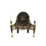 AN EARLY 19TH CENTURY IRON AND BRASS FIRE GRATE, of serpentine form, the domed top above pierced