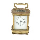 A SMALL BRASS CARRIAGE CLOCK, with white enamel dial marked 'Finnegans Paris'. 10cm high