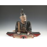 A JAPANESE CARVED PAPIER MACHE FIGURE OF A SEATED SHINTO PRIEST, (Tenjin), late 19th century, with