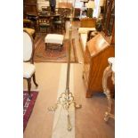 AN EDWARDIAN BRASS COLUMN STANDARD LAMP, with reeded column raised on shaped tripod supports and