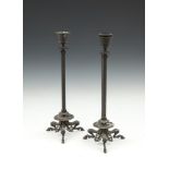 A PAIR OF 19TH CENTURY BRONZE EMPIRE STYLE TALL CANDLESTICKS, with leaf capitals and fluted