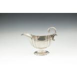 AN EDWARDIAN SILVER PEDESTAL SAUCE BOAT, London 1908, of shaped oval form with panelled body,