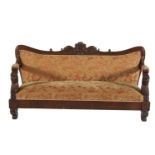 A 19TH CENTURY CONTINENTAL MAHOGANY SETTEE, the shaped back carved with central figural decoration