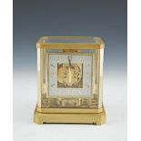 A JAEGER LE COULTRE ATMOS MANTLE CLOCK, in fitted case, with clear glass top and side panels, angled